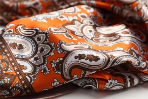 Makroaufnahme von hochwertigem Paisley-Satin-Seidenschal mit orange-braunen Details