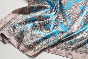 Detail eines Seidenschals mit Paisley-Muster in Petrol und Champagner-Satin-Finish