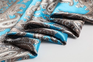 Detailansicht eines himmelblauen Seidenschals mit Paisley-Muster und elegantem Seidenglanz