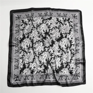 Detailaufnahme des quadratischen Seidenschals mit schwarz-weißem Paisleymuster und Satinstoff