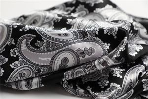 Makroaufnahme von luxuriösem schwarzem Paisley-Satinstoff mit elegantem Seidenglanz