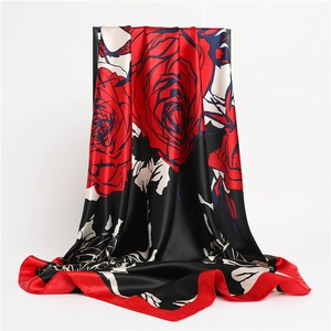 Detail of red rose silk scarf showing vibrant floral pattern and smooth satin texture