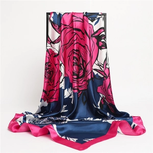 Detailed view of red rose floral print satin scarf with elegant draped silk texture