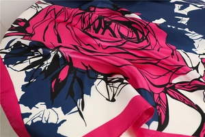 Detail of silk-like rose floral scarf with satin luster and deep blue floral patterns
