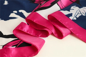 Macro shot of elegant rose red and navy silk-like scarf showing smooth satin texture