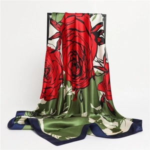 Close-up of red rose floral print silk scarf with smooth satin texture and blue border