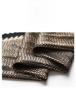 Macro shot of pleated satin fabric with gold and black houndstooth pattern detail