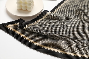 Detailed view of accordion pleated square scarf featuring black and white houndstooth pattern