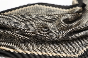 Detail shot of the pleated houndstooth silk scarf showing texture and elegant folds