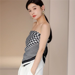 Detail of houndstooth silk scarf worn as a stylish tube top with high-waisted pants