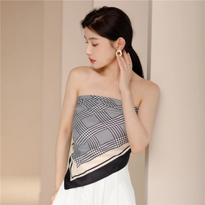 Detail of houndstooth silk tube top featuring an asymmetrical scarf hem and chic pattern