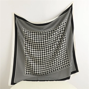 Detailed view of large black and white houndstooth pattern scarf with silk-like texture