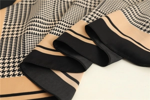 Close-up of houndstooth silk scarf showing smooth texture and khaki geometric design