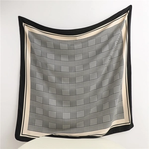Detail of elegant houndstooth pattern silk scarf with black border and soft drape texture