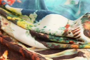 Macro view of colorful artistic print on silk-like twill fabric scarf showing soft folds