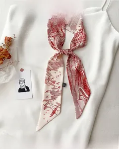 Détail d'un foulard en soie vintage aux motifs floraux rouges sur tissu beige