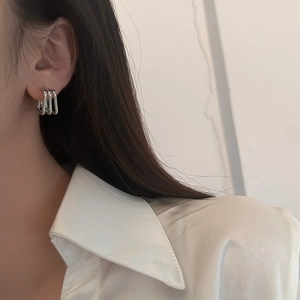 Minimalist silver geometric three-layer rectangular drop earrings worn by a model