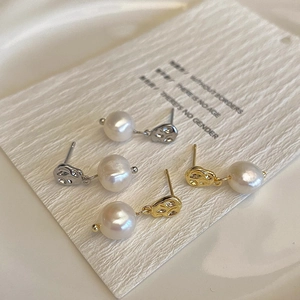 Macro detail of irregular gold and silver metal earrings with natural pearl drops