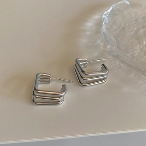 Macro detail of S925 sterling silver stamp on minimalist geometric triple layer square studs