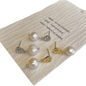 Irregular textured gold and silver pearl earrings set on minimalist display card