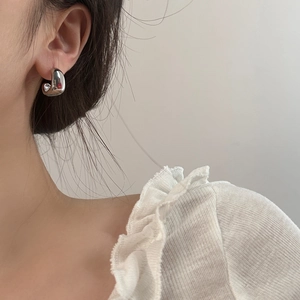 French geometric silver thick C-shape earrings shown on model with polished mirror finish