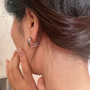 French style minimalist silver geometric C-shape chunky hoop earrings on model ear