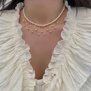 Elegante girocollo di perle barocche con nappe dorate indossato da una modella