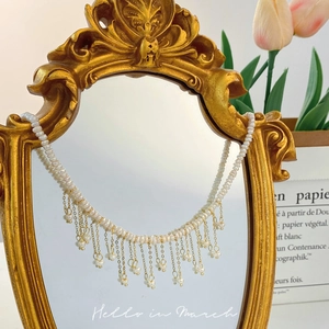 Dettaglio della collana di perle d'acqua dolce barocche con nappe dorate stile retrò