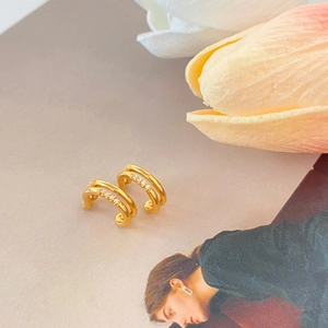 Detail of gold-plated double-layer ear cuffs with micro-paved cubic zirconia stones