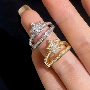 Detail of star-shaped rings with sparkling zircons in gold and silver plating