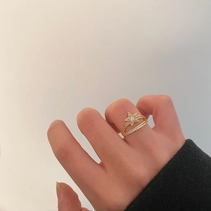 Close-up of gold star ring featuring pavé-set zircon stones and adjustable band
