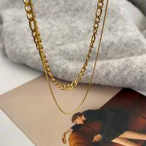 Minimalist double-layered gold necklace featuring a Figaro chain and a fine snake chain
