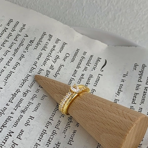 Dettaglio di un anello con zircone a goccia su supporto in legno con sfondo vintage