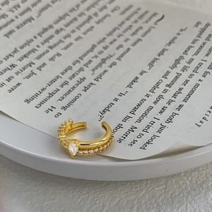 Macro dell'orecchino ear cuff dorato con zircone a pera e dettaglio micro-pave