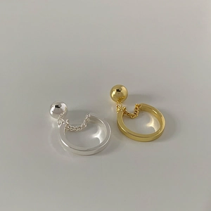 Close-up of minimalist chain ring and metal bead in gold and silver finish
