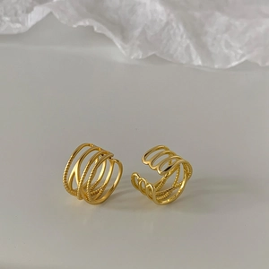 Detail of gold-plated multi-layer ear cuffs with elegant twisted rope metal textures