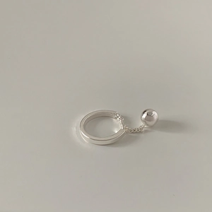 Detailed close-up of a silver minimalist chain ring with a polished bead pendant detail