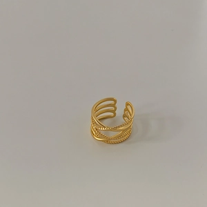 Macro detail of multi-layered gold plated interlocking rings with woven texture finish