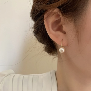 Boucles d'oreilles pendantes en or avec perles blanches pour un style minimaliste
