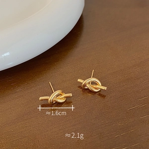 Detail view of gold knot stud earrings with size and weight measurements specified