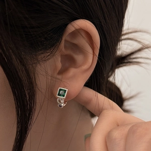 Vintage emerald-green and purple zircon earrings in silver finish worn by a model