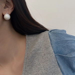 Close-up of retro silver glass bead earrings with beaded edges worn on earlobe