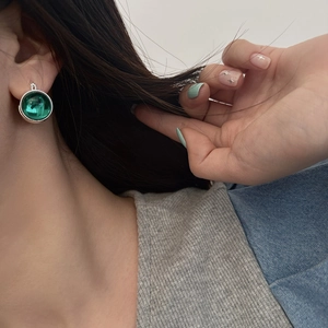 Retro emerald green glass dome earrings with beaded silver base on female model