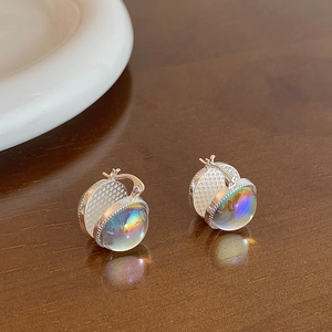 Detailed view of silver huggie earrings with iridescent glass domes and beaded edges