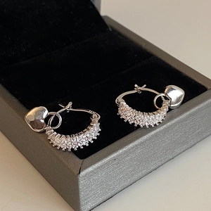 Detail of silver heart earrings with sparkling cubic zirconia on a black velvet box