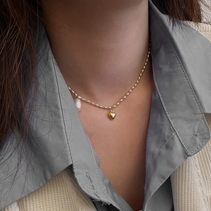 Détail du collier vintage français avec pendentif cœur doré et perle baroque sur chaîne perlée