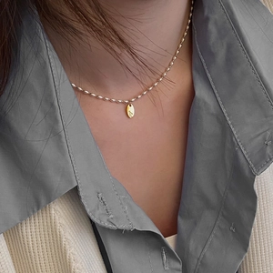 Collier minimaliste en perles argentées avec pendentif ovale doré gravé de la lettre S