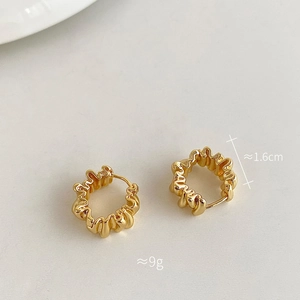 Détail de créoles dorées à texture ondulée avec taille de 1,6cm et poids de 9g