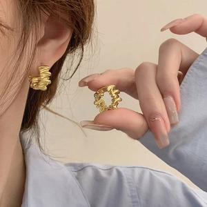 Vue détaillée des boucles d'oreilles créoles dorées vintage avec texture ondulée