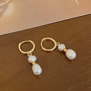 Close-up of vintage gold hoop earrings with dual natural freshwater pearls and beads